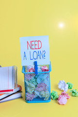 Handwriting text writing Need A Loan Question. Conceptual photo asking he need money expected paid back with interest Trash bin crumpled paper clothespin empty reminder office supplies yellow