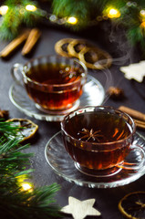 Couple cups of hot spicy tea with anise and cinnamon, selective focus.