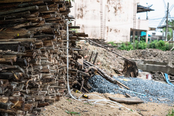 Pile of old used timber wood used for scaffolding and structure in house building construction in Thailand.