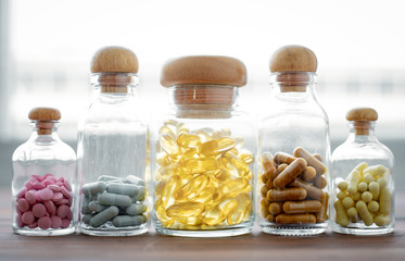 Medicine in glass bottle on wood background.