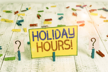 Text sign showing Holiday Hours. Business photo text employee receives twice their normal pay for all hours Scribbled and crumbling sheet with paper clips placed on the wooden table