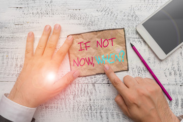 Obraz premium Handwriting text writing If Not Now When Question. Conceptual photo start acting from this moment do not hesitate Hand hold note paper near writing equipment and modern smartphone device