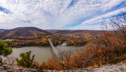 Bridge crossing a river to a forest of vibrant fall foliage colors. Bear Mountain, Hudson River Valley New York. 