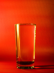 Water glass with orange color grunge background 