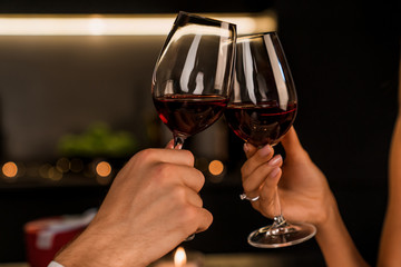 Close up shot of man and woman toasting and drinking red wine from glasses on dinner - Powered by Adobe