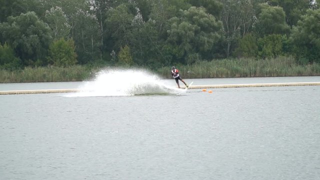 Sportsman is gliding on water and jumping in the air with a spin