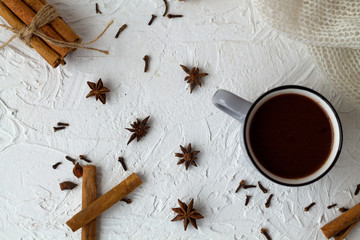 cup of hot chocolate or cocoa and cinnamon, anise stars on white background. top view. copy space. winter and autumn hot drinks