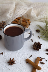 cup of hot chocolate or cocoa and cinnamon, anise star with pine cone and green spruce branch on white background. winter and autumn hot drinks
