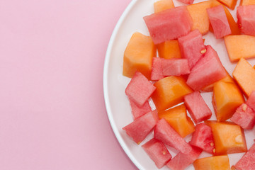 Sliced watermelon and cantaloupe melon on a white plate.