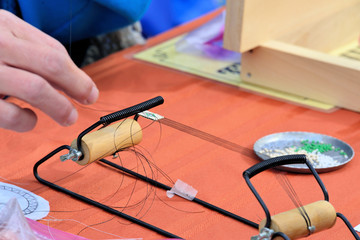 Creating a beaded strip using a small beading loom.