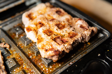 Barbecue pork is fried on electricity and served to the table to celebrate and eat food with fresh meat