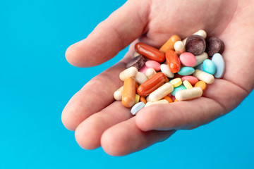 A handful of colored pills on the palm. Medical concept. Shopping at the pharmacy.