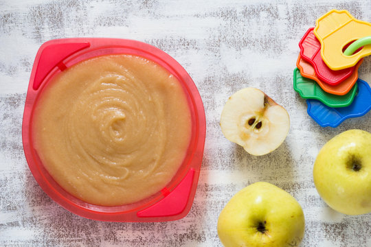 Top View Of Apple Sauce On Plastic Red Plate For Kids On The White Background