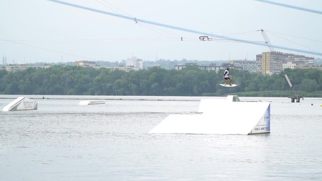 Wakeboarding stunts on the ramp, jumping and spinning