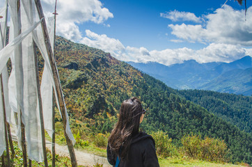 Woman traveller enjoying the picturesque view of Chele la pass in Bhutan in the midst of flapping...