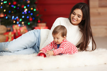 Mother and her cute baby at home. Christmas celebration
