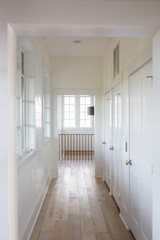 White Hallway with Natural Wood Floors