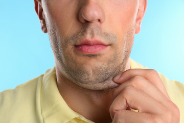 Fototapeta premium Young man with double chin on blue background, closeup