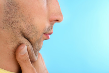 Naklejka premium Young man with double chin on blue background, closeup. Space for text