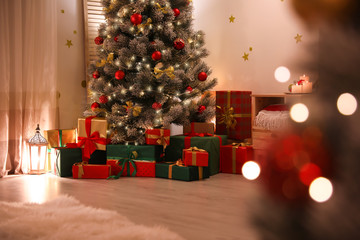 Fototapeta na wymiar Stylish room interior with beautiful Christmas tree and gift boxes
