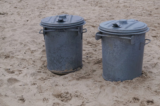 Two garbage bins on a beach