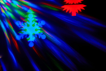rays of light on a black background. Colored snowflakes and christmas trees