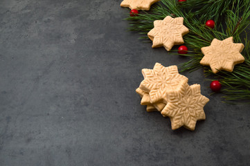 Christmas holly on a concrete background and fragrant homemade cakes.