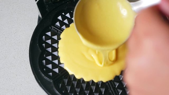 Cooking waffles in a waffle iron.