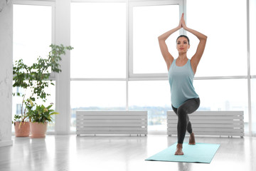Fototapeta premium Young woman practicing crescent asana in yoga studio. High lunge pose