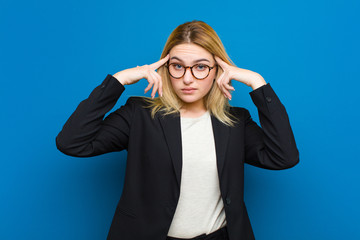 young pretty blonde woman with a serious and concentrated look, brainstorming and thinking about a...