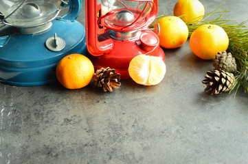 Blue and red oil lamps surrounded by manadrins, cones and hvony branches.