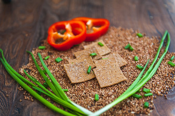 wheat crackers shooted with different  vegetables,groats,honey,seeds,salt on different surfaces