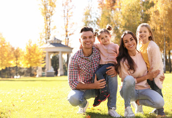 Happy family with little daughters in park. Autumn walk