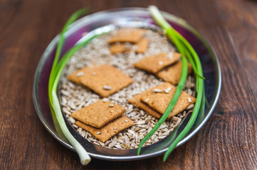 wheat crackers shooted with different  vegetables,groats,honey,seeds,salt on different surfaces