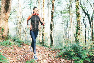 Young caucasian woman runner on a forest trail. Exercise in the fresh air. Healthy lifestyle.