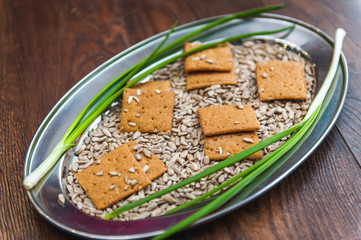 wheat crackers shooted with different  vegetables,groats,honey,seeds,salt on different surfaces