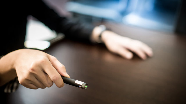 Male Hand Holding Laser Pointer In Meeting Room. Tool For Business Presentation. Teaching Concept