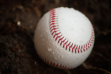 Baseball ball with red seams and water droplets. Sport, hobbies and Home Run concept. Extreme closeup