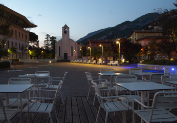 torbole city plaza with church and tables in front of a restaurant / cafe