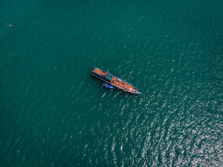 Drone view of the big old blue motorboat with huge empty deck in blue sea, violet lifeboat at its side; vessels concept.
