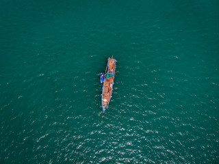 Drone view of the big old blue motorboat with huge empty deck in blue sea, violet lifeboat at its...