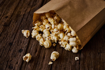 Delicious popcorn with caramel on wooden background..