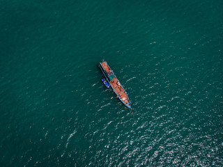 Drone view of the big old blue motorboat with huge empty deck in blue sea, violet lifeboat at its side; vessels concept.