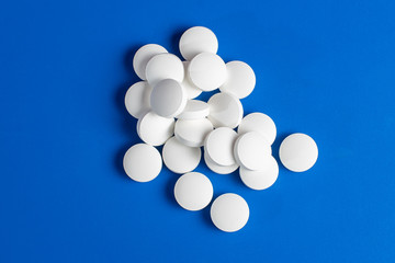 white round pills scattered blue background, chaotically scattered.