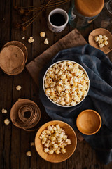 Delicious popcorn with caramel on wooden background..
