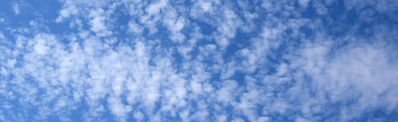 Obraz premium Weiße Schäfchenwolken vor blauen Himmel - Hintergrund