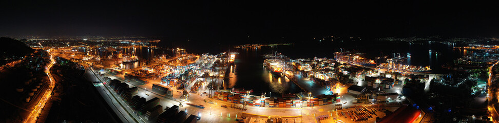 Aerial night shot of illuminated industrial cargo truck size container terminal in Asia port
