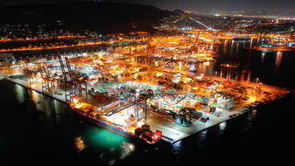 Aerial night shot of illuminated industrial cargo truck size container terminal in Perama and Drapetsona commercial port near Piraeus, Attica, Greece