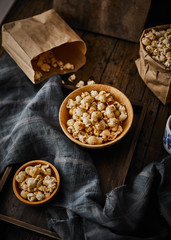 Delicious popcorn with caramel on wooden background..