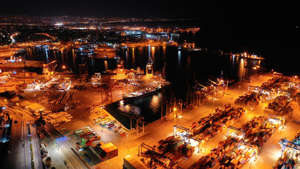 Aerial night shot of illuminated industrial cargo truck size container terminal in Perama and...